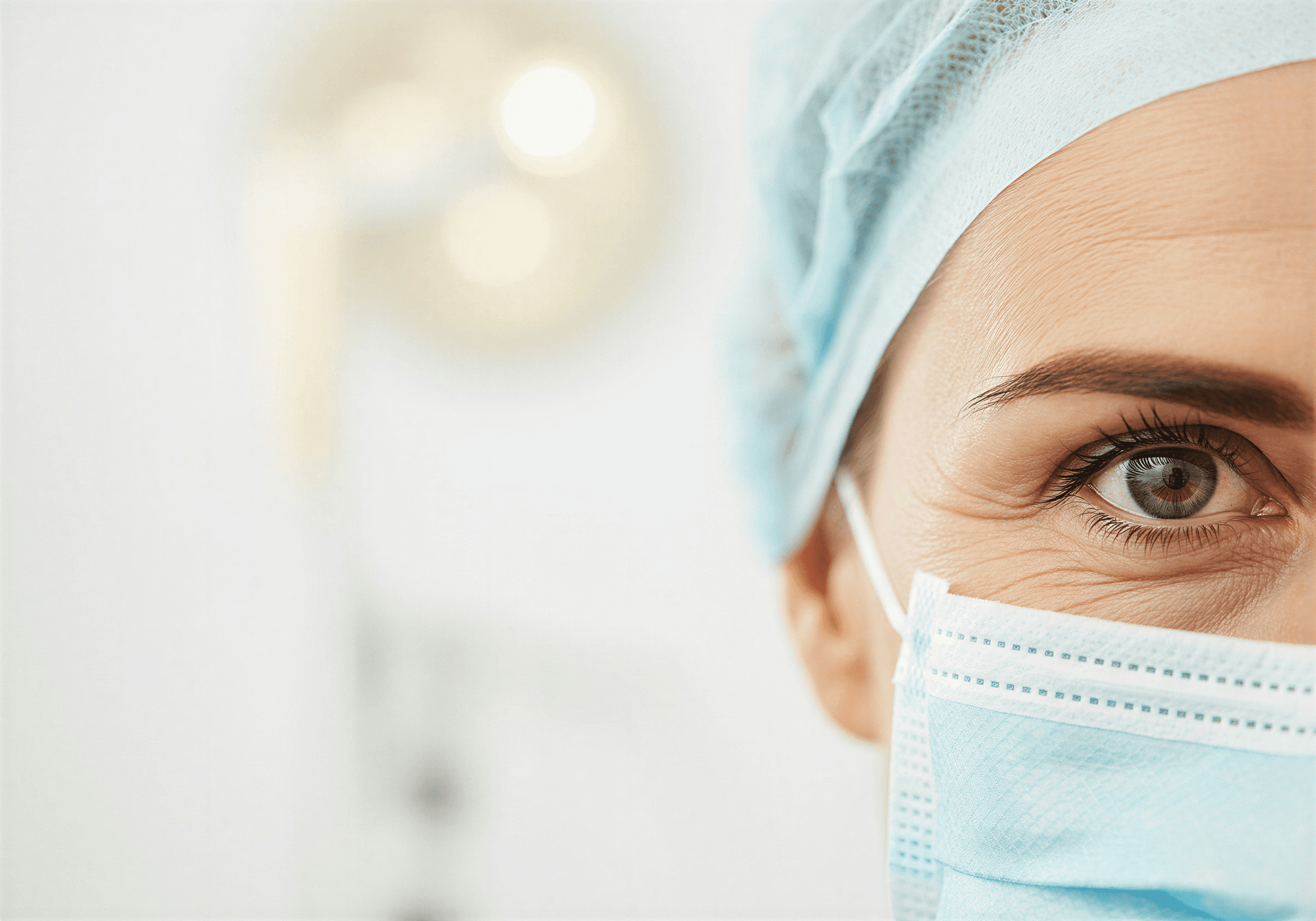 Close-up of a surgeon in a surgical cap and mask, in a practice using Reviva software for surgical and aesthetic clinics